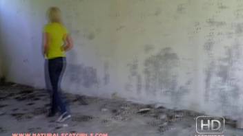 Young woman in a yellow tee performing scat fetish in a deserted house