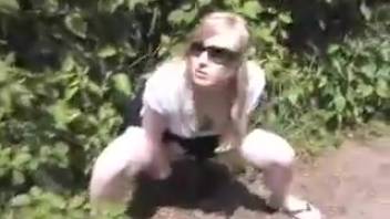 Young woman urinating by the roadside